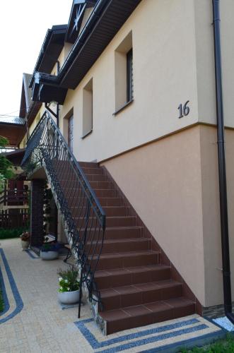 a staircase leading up to a house with the number at Kornatka Hajnówka Pokoje Puszcza Białowieska in Hajnówka
