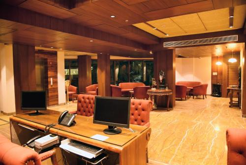 Hotel Royale Retreat - Luxury Hotel In Shimla في شيملا: لوبي فيه مكتب وبه كمبيوتر وكراسي