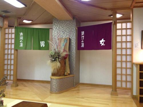 a room with two flags and a vase on a table at Kasuitei Ooya in Fujikawaguchiko