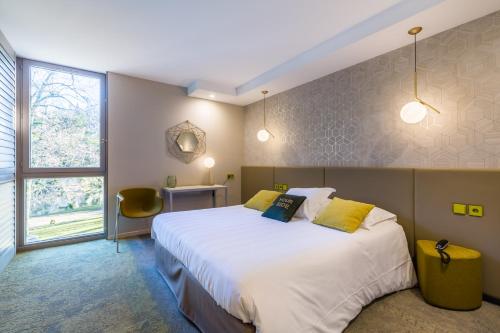 ein Schlafzimmer mit einem großen weißen Bett und einem Fenster in der Unterkunft Hôtel Restaurant du Château de la Tour in Béguey