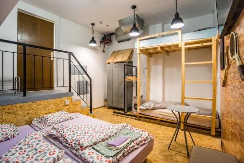 a room with two bunk beds and a table at HOSTEL NPOZNAM in Ljubljana