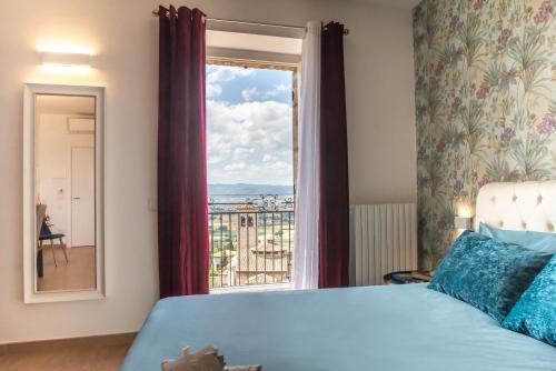 a bedroom with a bed and a large window at Assisi Panoramic Rooms in Assisi