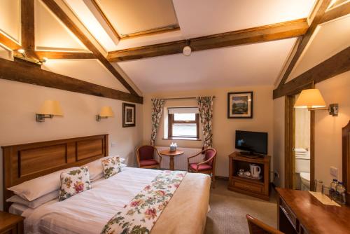 - une chambre avec un lit, une table et une télévision dans l'établissement Oranmore, à Ballymena