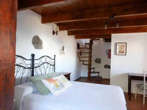 una camera da letto con un letto bianco e una scala di Casa Rural Los Llanillos a Frontera