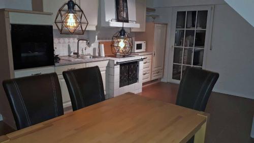 eine Küche mit einem Holztisch und schwarzen Stühlen in der Unterkunft Sissi's Feriendomizil in Winterberg