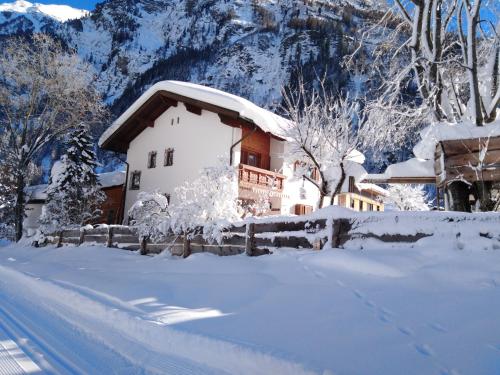 a house covered in snow in front of a mountain at Haus am rechten Fleck in Kaunertal