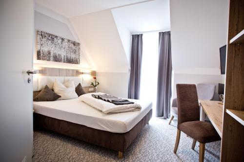 ein Hotelzimmer mit einem Bett und einem Stuhl in der Unterkunft Amtsstüble Hotel & Restaurant in Mosbach