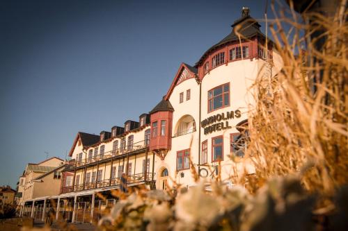 a large building with many windows on a street at Waxholms Hotell in Vaxholm