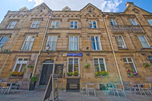 un edificio con mesas y sillas delante de él en The Mitre Hotel, en Mánchester