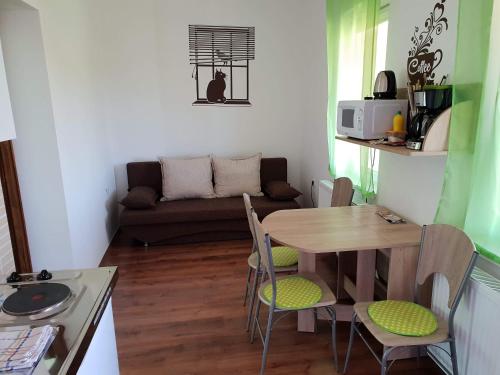 a small living room with a table and a couch at Kókusz Apartmanok in Eger