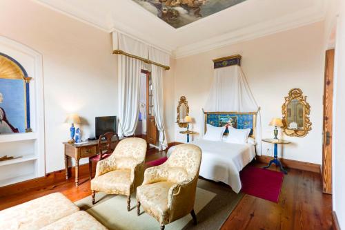 a bedroom with a bed and two chairs at La Casona de Yaiza in Yaiza