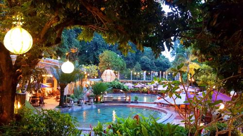a large swimming pool in a garden at night at Gracia Spa Resort Hotel in Ciater