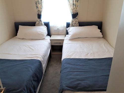 Un pat sau paturi într-o cameră la Tattershall Lakeside Lodge Indulgent wheelchair accessible 8 berth with Hot Tub
