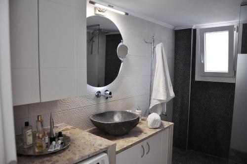 a bathroom with a bowl sink and a mirror at Unique flat of refined luxury and splendid views. in Kavala