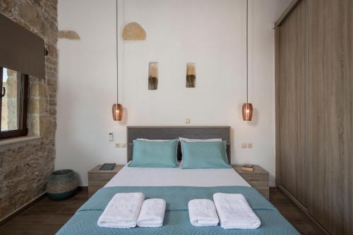 a bedroom with a bed with two towels on it at Doro Villas in Drapaniás