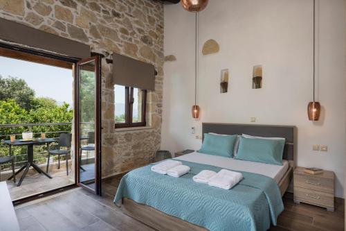 a bedroom with a bed and a balcony with a table at Doro Villas in Drapaniás