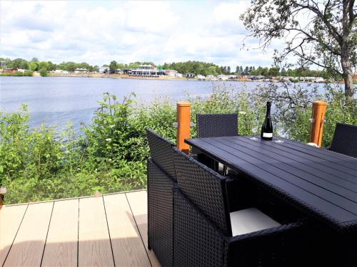 a bottle of wine sitting on a table next to a lake at Tattershall Lakeside Lodge Indulgent wheelchair accessible 8 berth with Hot Tub in Tattershall