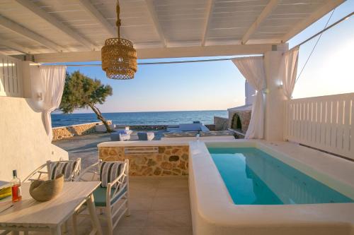 a villa with a swimming pool and the ocean at Aegean Melody Suites & Villas in Vlychada