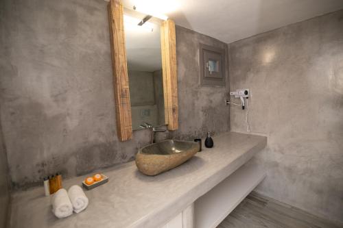 a bathroom with a bowl sink and a mirror at Aegean Melody Suites & Villas in Vlychada