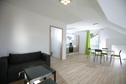 - un salon avec un canapé, une table et des chaises dans l'établissement Hotel am Baronenwald, à Göppingen