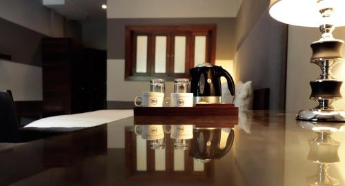 a table with cups and a coffee maker on it at The Residency Hotel in Lahore