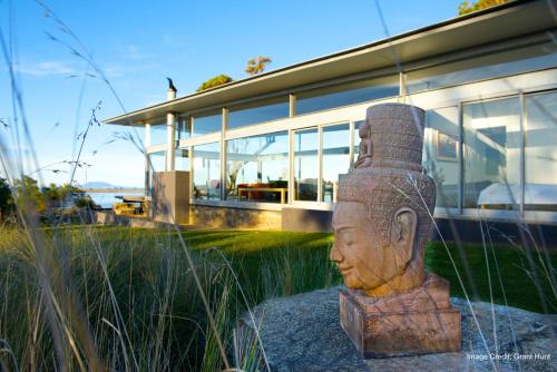 a statue of a head in front of a house at Avalon Coastal Retreat in Swansea