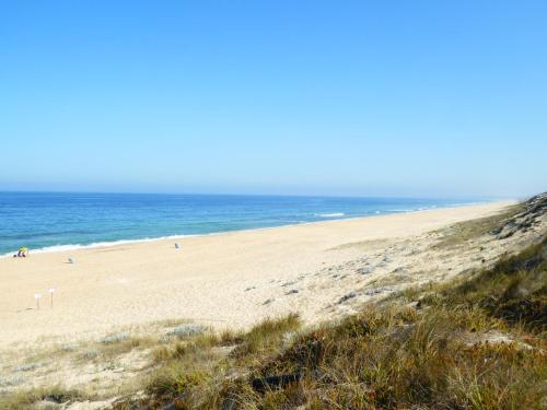 a sandy beach with the ocean in the background at Monte da Cascalheirinha in Santo André