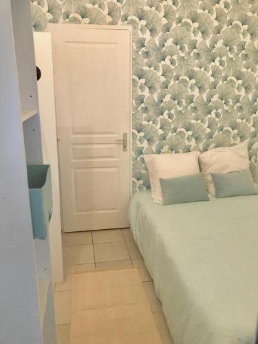 - une chambre avec un lit orné d'un mur fleuri dans l'établissement Jolie T2 la ciotat, à La Ciotat