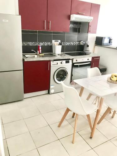 une cuisine avec une table, une cuisinière et un lave-vaisselle dans l'établissement Jolie T2 la ciotat, à La Ciotat