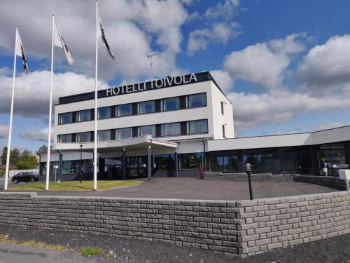 a hotel with two flags in front of a building at Hotelli Toivola in Kemi
