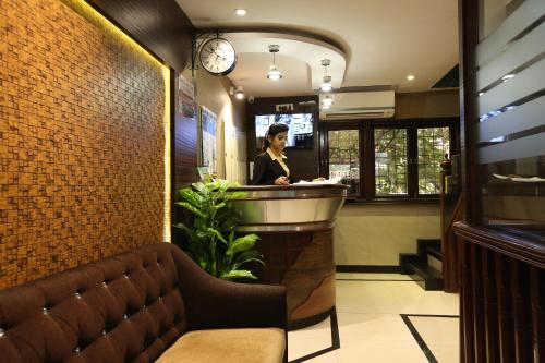 a woman standing at a bar in a restaurant at Hotel Happyland in Mumbai