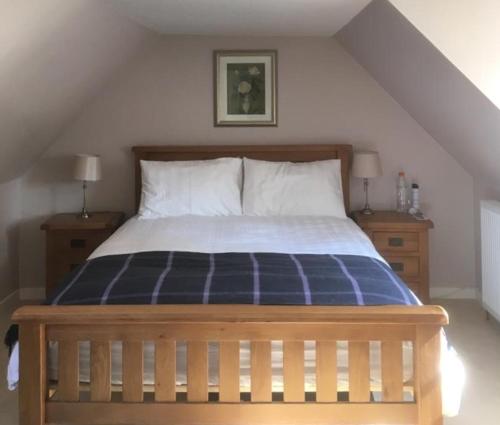 a bedroom with a blue and white bed with two night stands at Springwells in Dunkeld