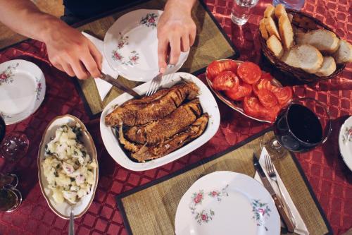 a table topped with a plate of food with meat and bread at Studio and winery Kalimut in Virpazar