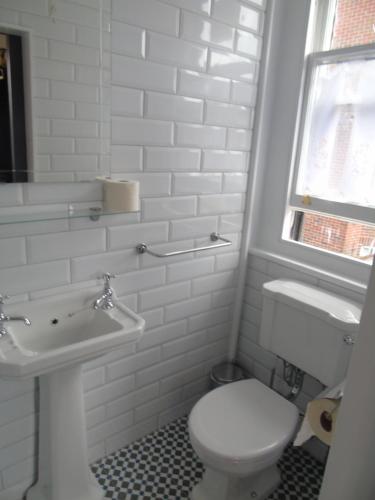 a white bathroom with a toilet and a sink at The Warren Belfast in Belfast