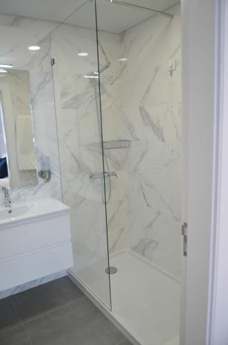 ein weißes Badezimmer mit Dusche und Waschbecken in der Unterkunft Edificio Charles 206 in Funchal