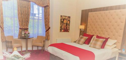 ein Schlafzimmer mit einem großen Bett mit roten Kissen in der Unterkunft Kingston Theatre Hotel in Hull