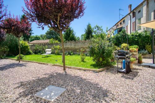 a small garden with a tree and a building at Villa Margherita Ecolodge in Crespino