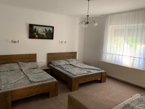 a bedroom with two beds and a window at Viktor Apartmanház in Zamárdi