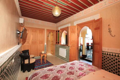 a bedroom with a bed and a room with a balcony at Riad Moulay Spa in Marrakech
