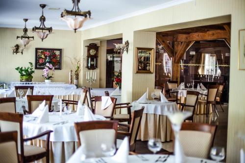 a dining room with white tables and chairs at Hotel Lubicz in Ustka