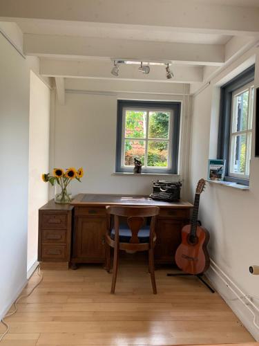 a kitchen with a wooden table and a guitar at Erve Feenstra in Lochem