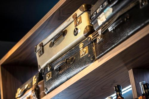 three suitcases stacked on top of each other on a shelf at Alex Maastricht in Maastricht