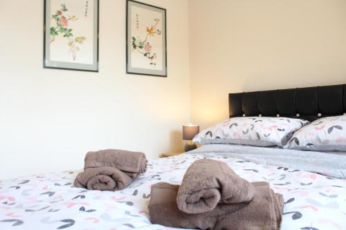 a bedroom with a bed with towels on it at Van Apartments in Caerphilly