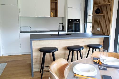 a kitchen with a counter with stools and a table at Regentova Suites Ljubljana in Ljubljana