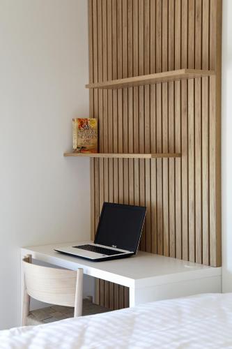 a laptop computer sitting on a white desk at Regentova Suites Ljubljana in Ljubljana