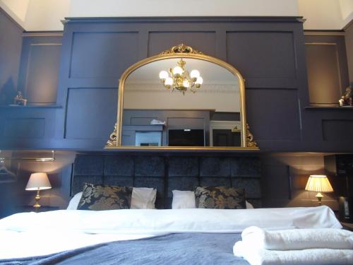 a bedroom with a large mirror above a bed at The Warren Belfast in Belfast