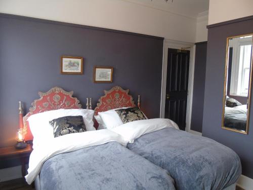 a bedroom with a large bed with blue walls at The Warren Belfast in Belfast