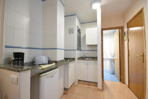 a kitchen with a sink and a refrigerator at Apartamentos Tinoca in Las Palmas de Gran Canaria
