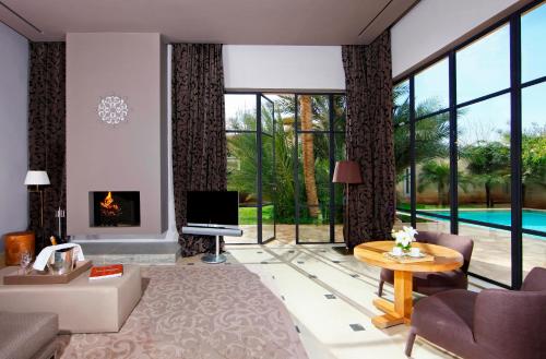 a living room with a fireplace and a tv at Palais Namaskar in Marrakech