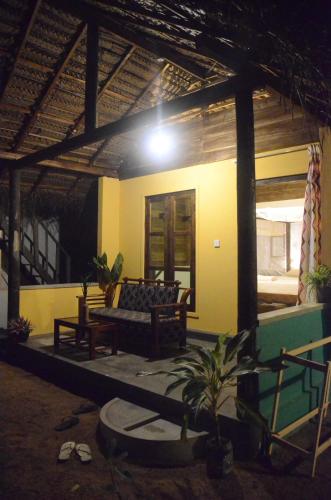 a living room with a couch in front of a house at Arne's Place in Arugam Bay
